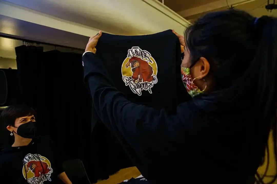 Picture of dancer holding up a sweatshirt
